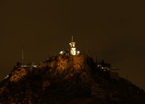 Illuminated Monastery atop a Grecian Hillside at Night