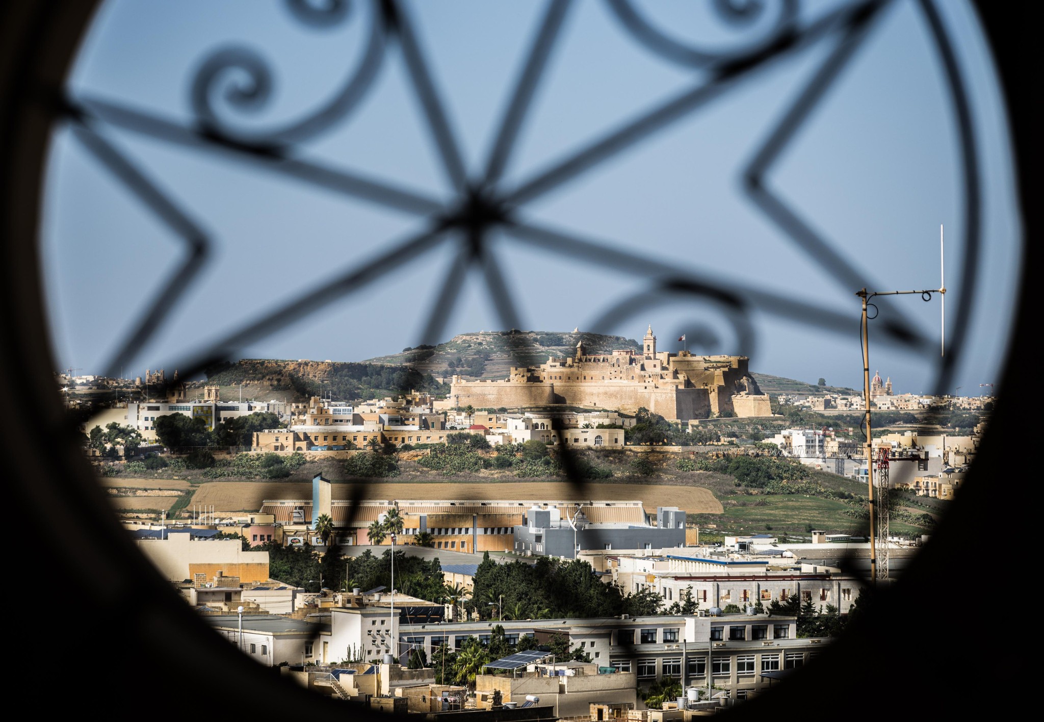 Mdina's Ancient Skyline Framed by Wrought Iron